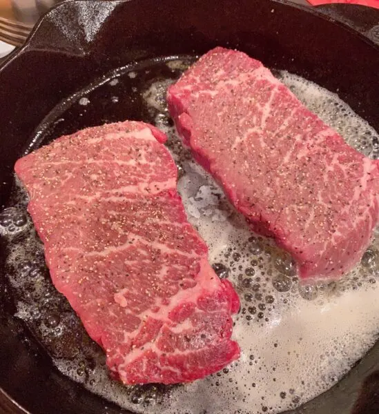 Adding Steaks to Hot skillet with olive oil and butter.