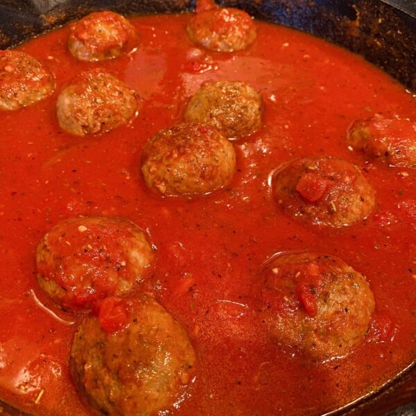 Skillet with pasta sauce and meatballs.