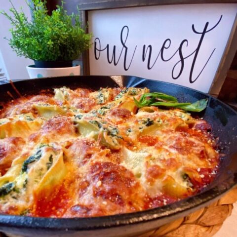 Cast Iron Skillet on the kitchen counter filled with Stuffed Shells and meatballs in a rich sauce.