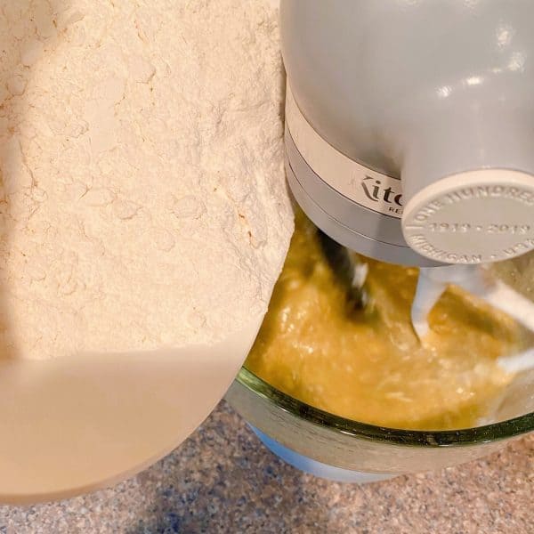 Adding dry ingredients into the wet ingredients in the mixer.