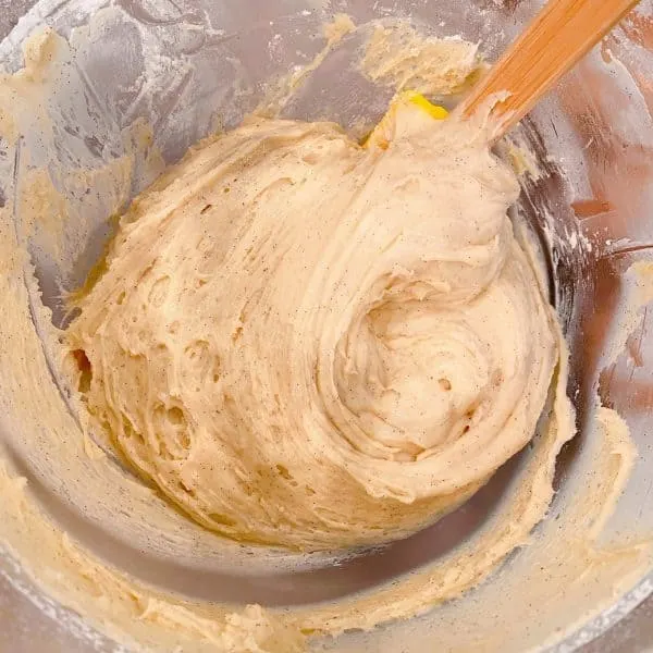 scraping dough down from the sides of the bowl