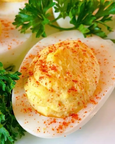 Close up of one deviled egg ready to eat.