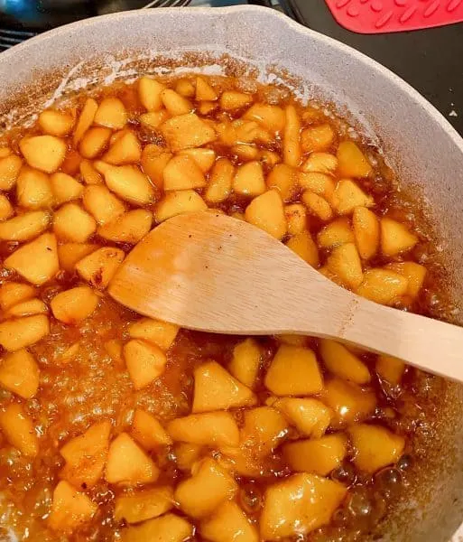 peaches frying in the skillet with brown sugar and spices.