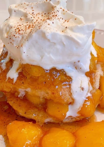 Fried Peaches and biscuit topped with whipping cream and nutmeg