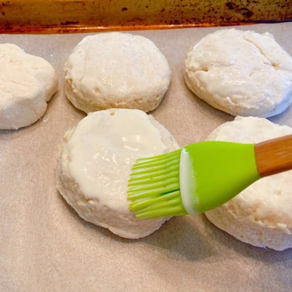 Brushing the top of each biscuit with heavy cream.