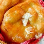 Four Indian Fry Breads in a basket with a red cloth napkin, fry bread with butter and honey.