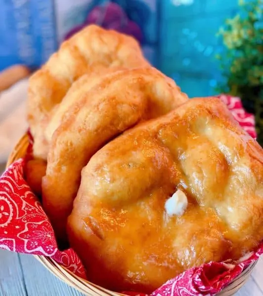 Basket full of Indian Fry bread with butter and honey.