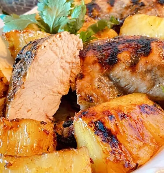 Chicken breast cut in half on the serving platter exposing tender juicy grilled chicken breasts.
