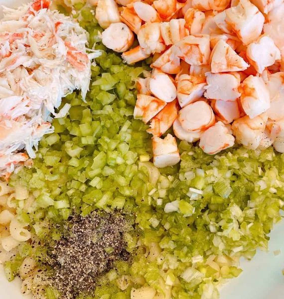 Adding chopped cooked shrimp, salt and pepper to the pasta salad preparations.