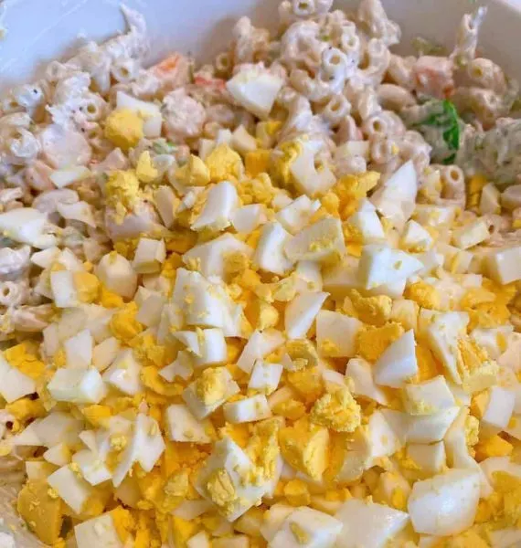 Adding hard boiled eggs to the salad mixture.