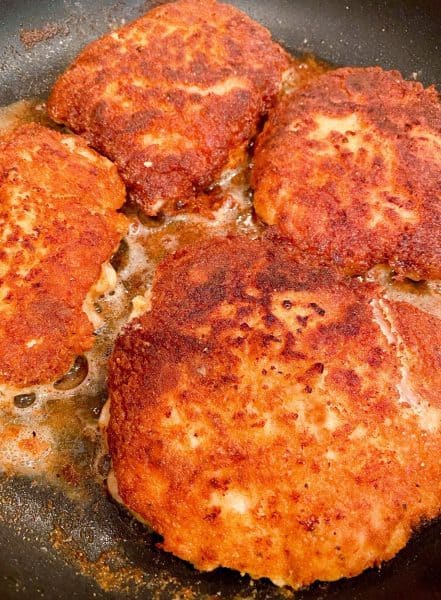 Skillet with four fried Pork Cube Steaks golden brown.