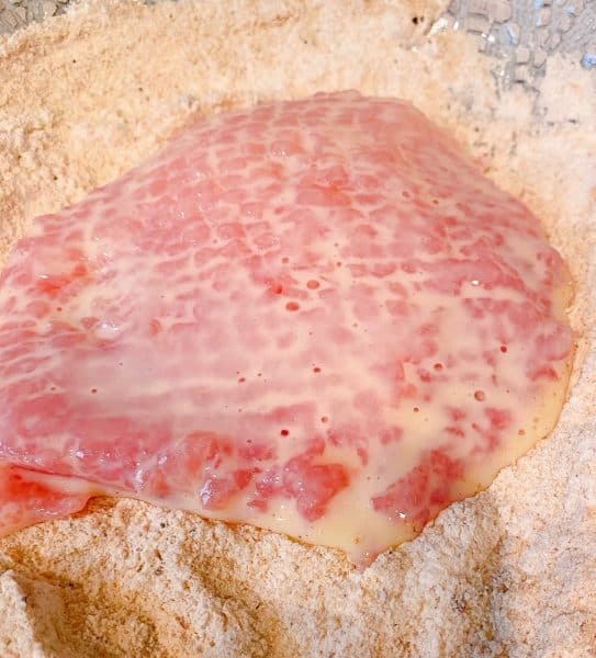 Dredging the pork steak in flour mixture