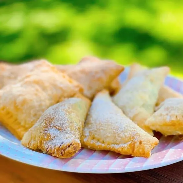 Plate full of Fried Hand Pies on a railing on a deck.