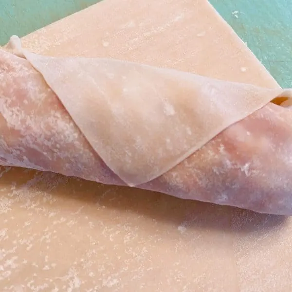 Egg Roll Wrapper stuffed and rolled up waiting to be fried.