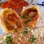 Homemade Pizza Roll cut open and marinara sauce in a bowl.