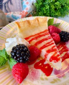 Slice of Water Depression Pie with Fresh berries and raspberry sauce