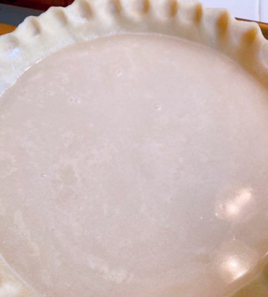 Water Pie with flour mixture sprinkled all over the top creating a cloudy water mixture.