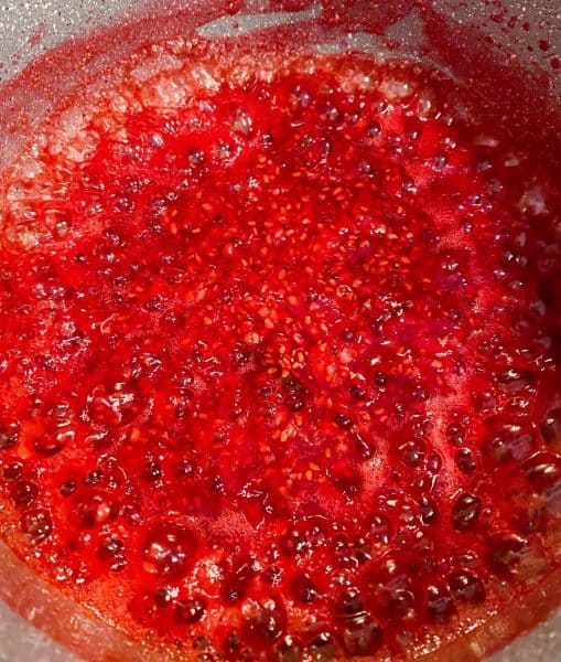 Fresh Raspberry Puree being cooked over medium heat in sauce pan.