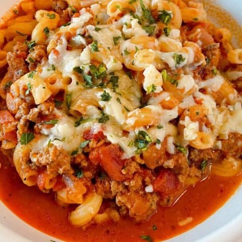 Easy One Pot Homemade Goulash close up in a bowl with melted cheese.