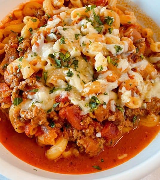 Easy One Pot Homemade Goulash close up in a bowl with melted cheese.