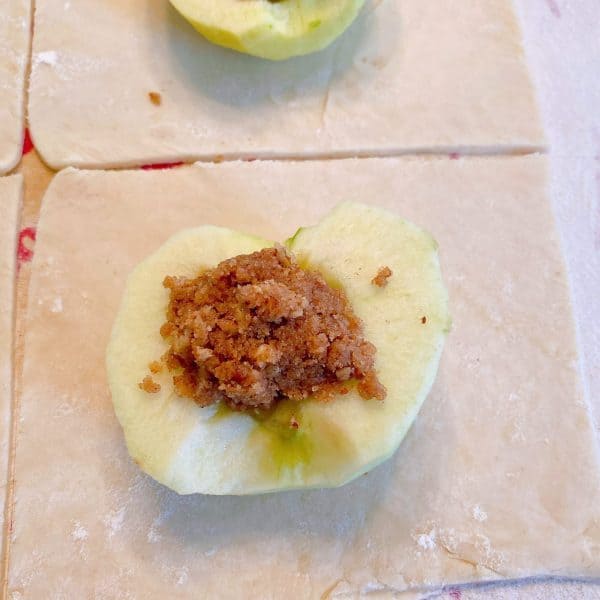 Apple half in the center of pie dough and center of apple core filled with cinnamon nut filling. 