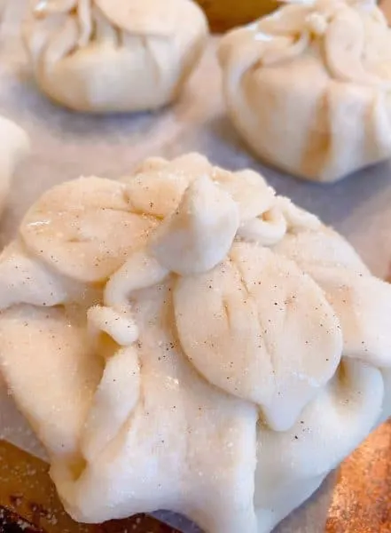 Apple dumpling with leaves and vines on top of each dumpling.