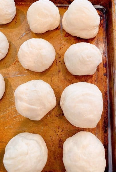 Pan dinner roll dough rolled into dinner rolls and placed on a prepared baking sheet.