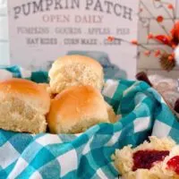 Basket full of Homemade Dinner Rolls with a side of raspberry jam