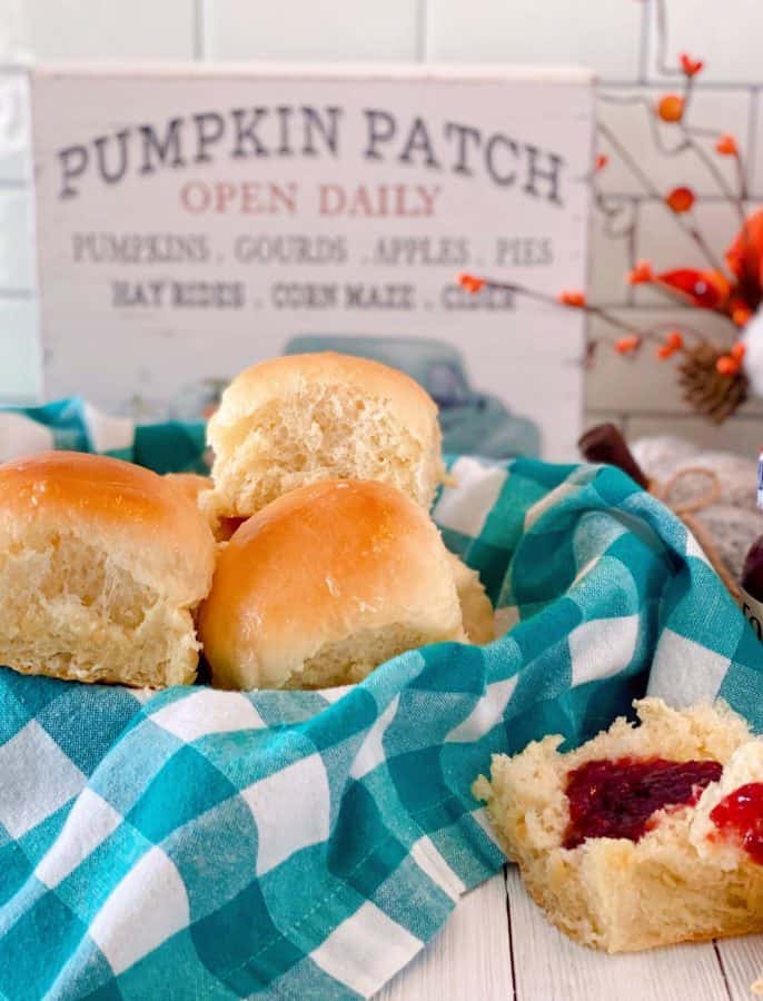 Basket full of Homemade Dinner Rolls with a side of raspberry jam