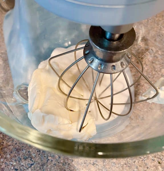 cream cheese and sugar in the bowl of mixer ready to blend.