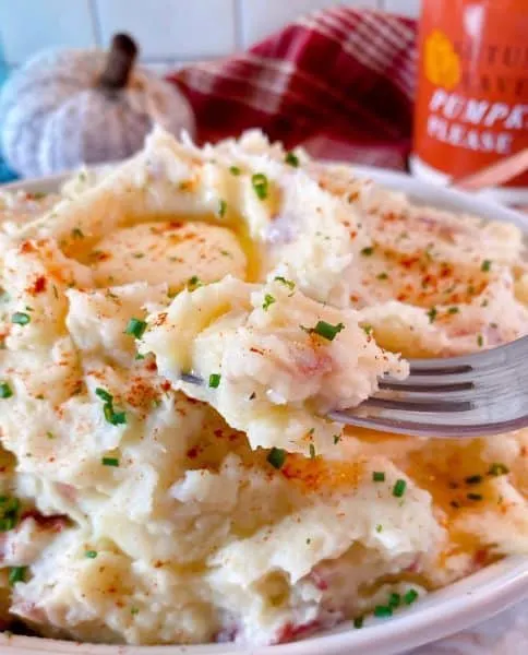 Fork taking a taste of the mashed potatoes.