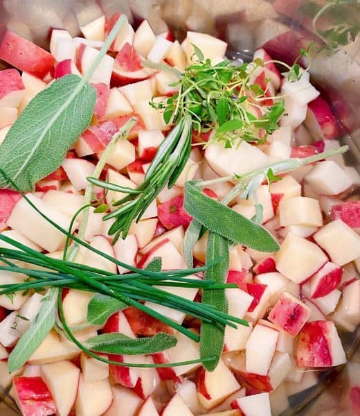 Diced up potatoes with fresh herbs on top in the Instant Pot.