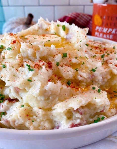 Savory Mashed Potatoes topped with melted butter, paprika, and chopped fresh chives.