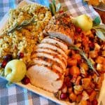 Herb Crusted Turkey Roast on a platter with roasted squash and stuffing.