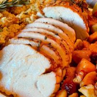 Herb Crusted Turkey Roast on a platter with side dishes.