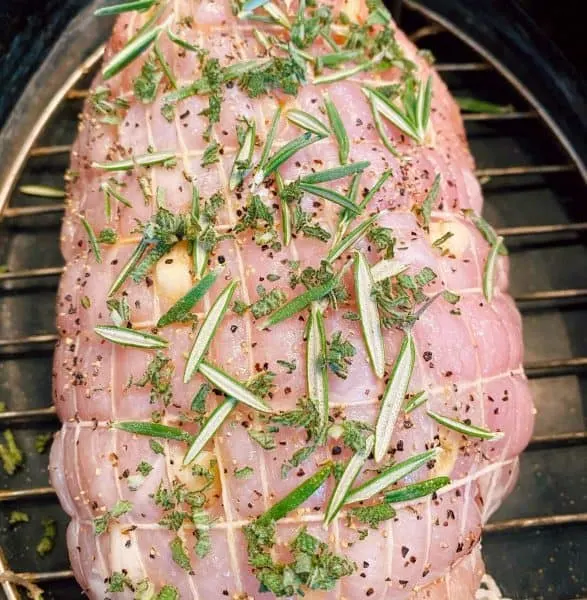 Roast covered with herbs and spices in the roasting pan.