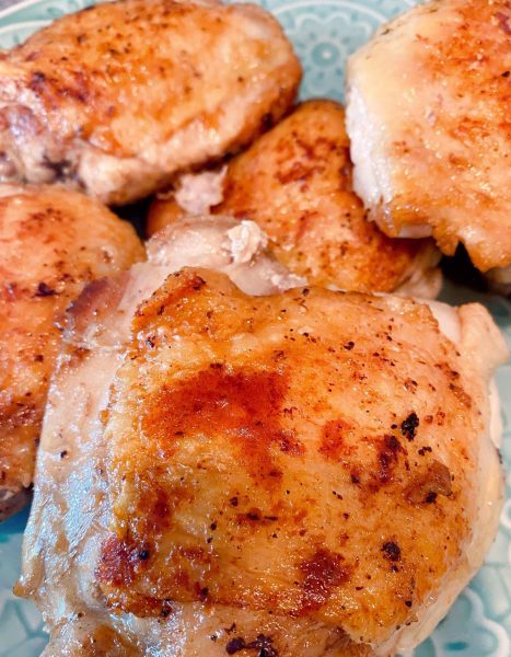 cooked chicken removed from skillet to a plate 