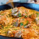 Skillet full of Chicken Thighs in Mushroom Cream Sauce