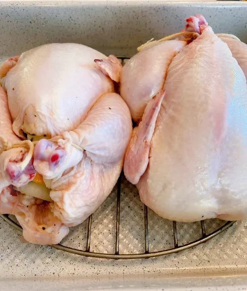 Hens on a roasting rack in a pan.