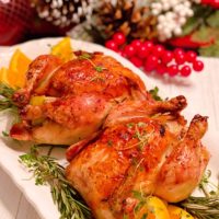 Roasted Cornish Game Hens on a platter with herbs