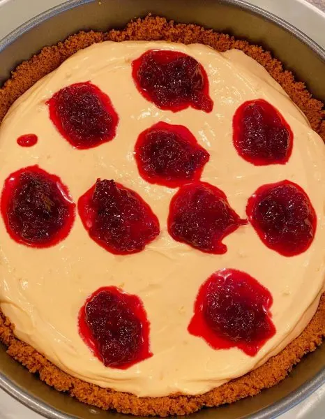 Dotting cheesecake with cranberry sauce