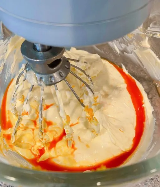 Orange flavoring being added to cheesecake.