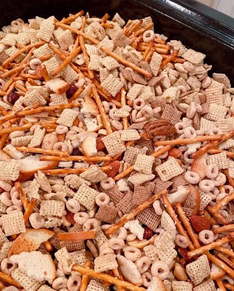 Cereals and pretzels mixed in a large roasting pan