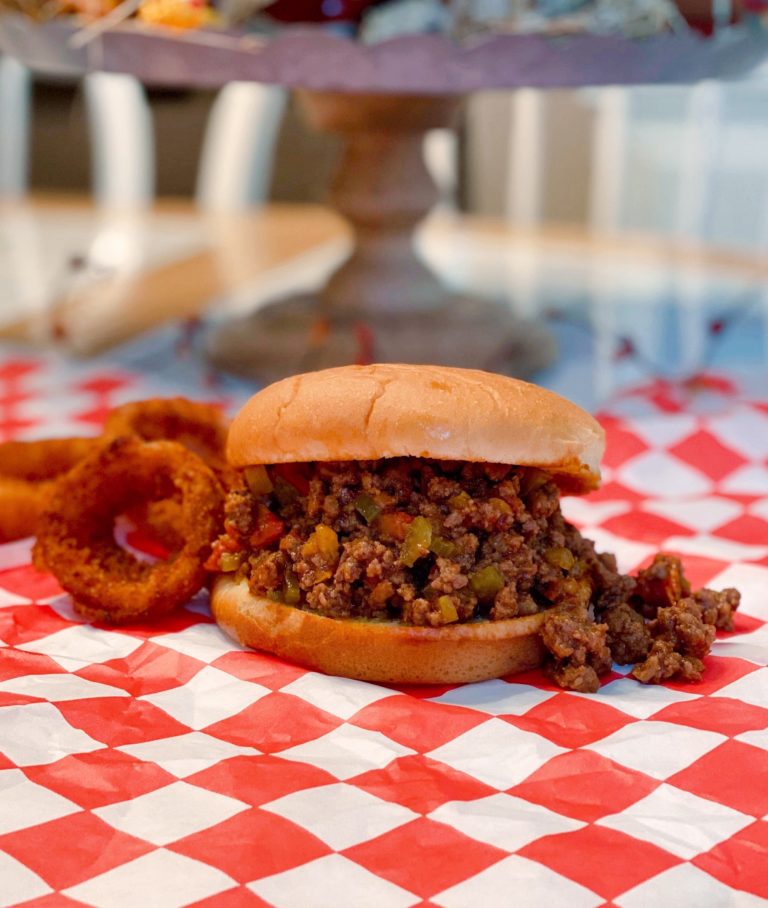 Easy Sloppy Joes on a checkered mat with onion rings