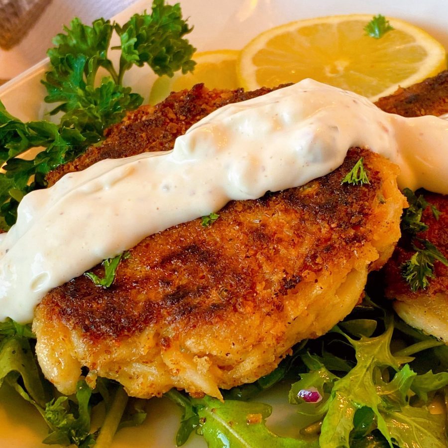 Lump Crab Cakes with homemade tartar sauce on a plate with arugala