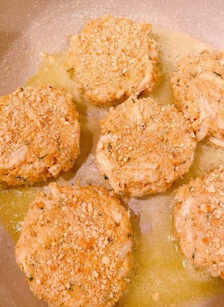 Crab Cakes cooking in skillet with butter.