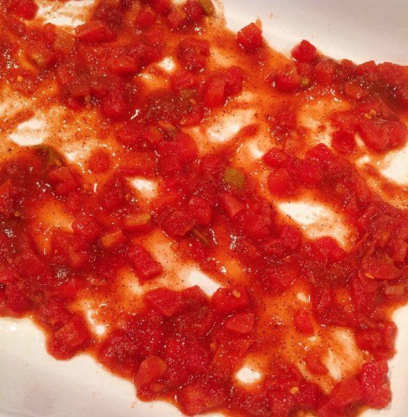 Red Tomato sauce spread on the bottom of baking dish.