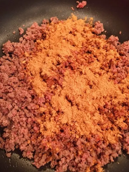 Browning Ground Beef and Taco seasoning in a large skillet over medium heat.