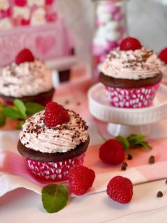 Cupcakes in a group with fresh raspberries and chocolate.