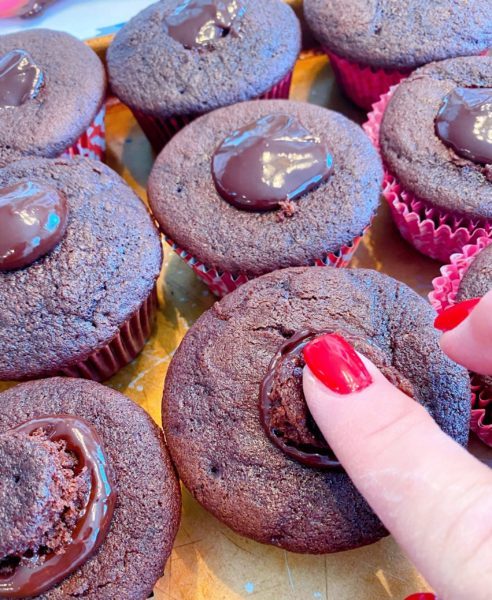 Pressing cupcake holes down into cupcakes.